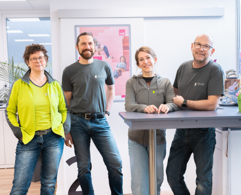 Auf dem Foto sieht man das Riedel Team von Weiden. Die vier Mitarbeiter stehen im Laden und schauen in die Kamera.